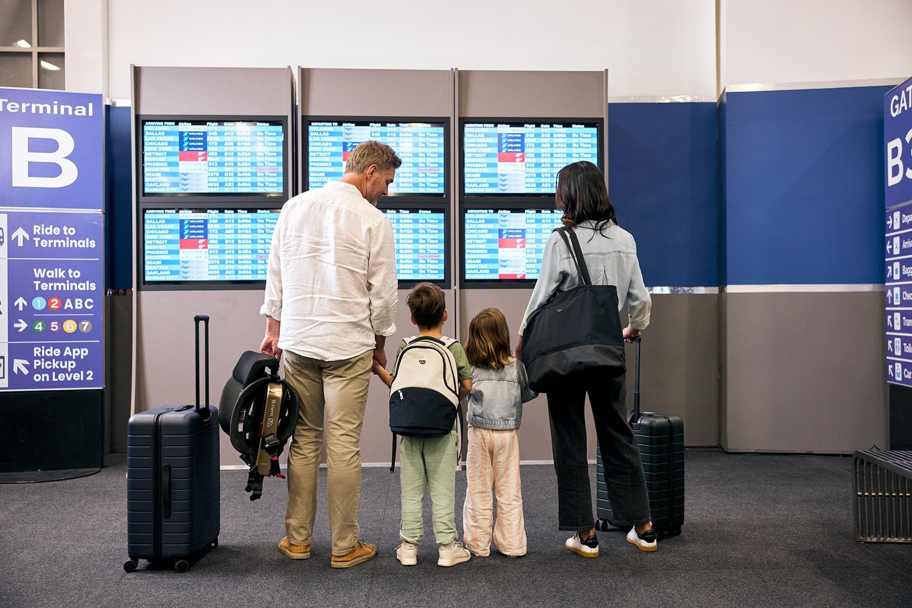 Family at an airport, carrying the Pico travel car seat