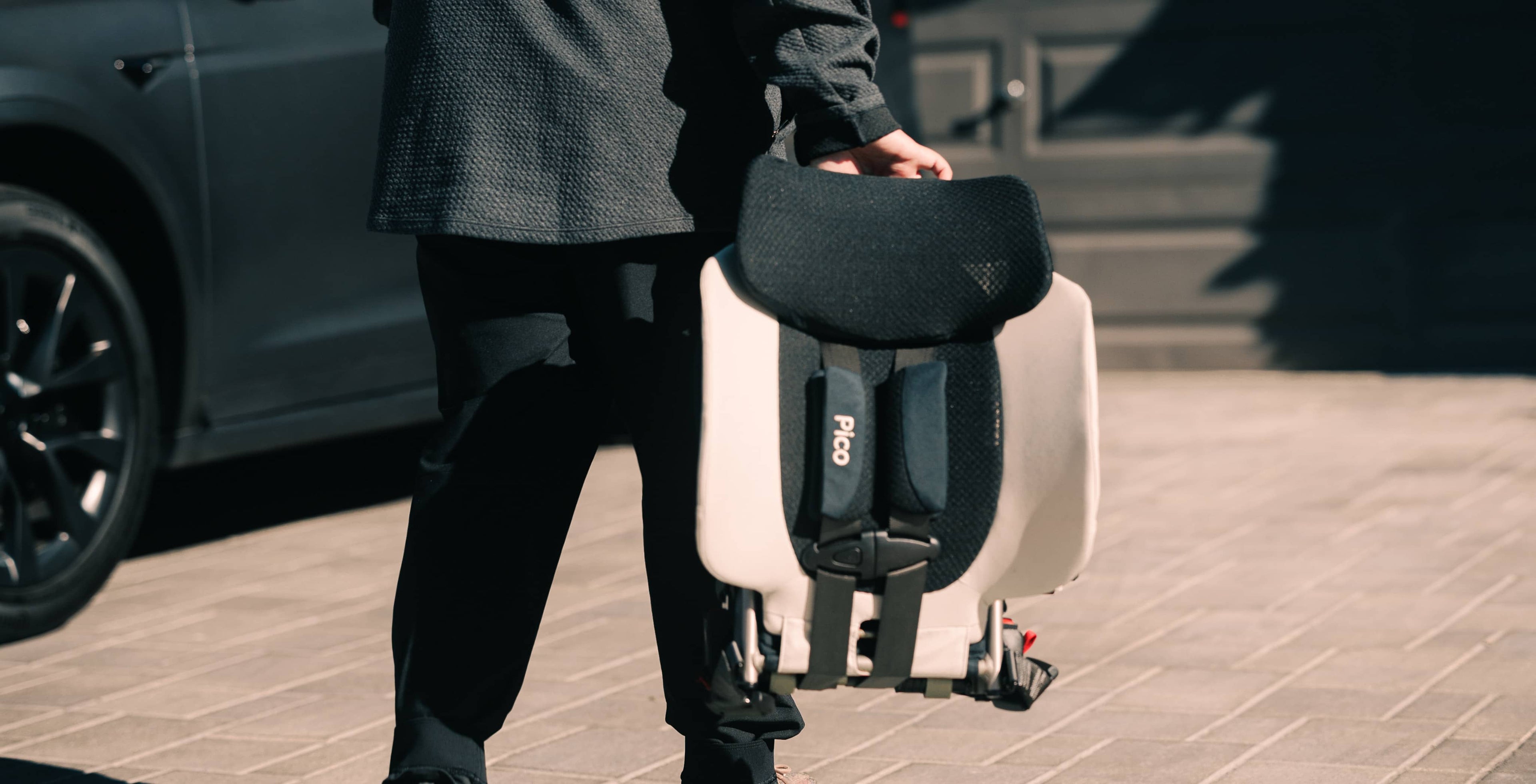 Parent carrying the foldable Pico car seat