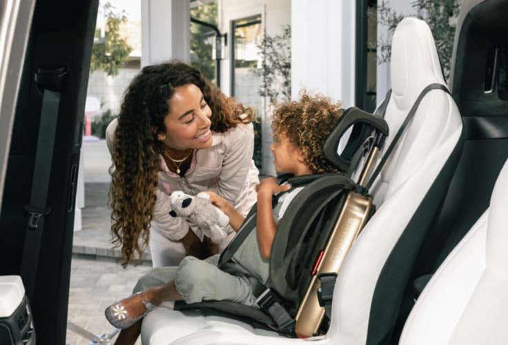 Mom putting her child in a WAYB Pico Car Seat