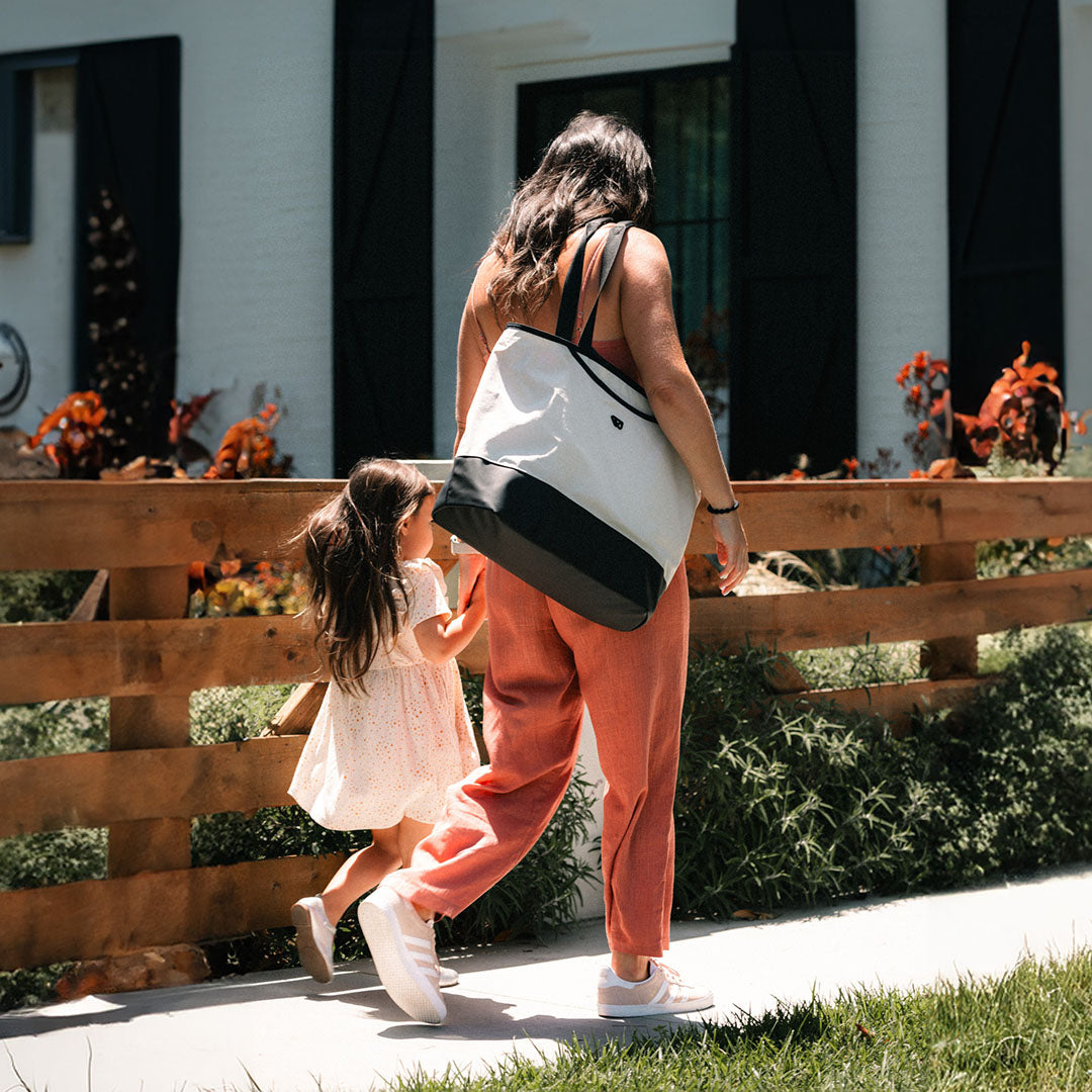 Parent walking with child carrying the Toddler Tote