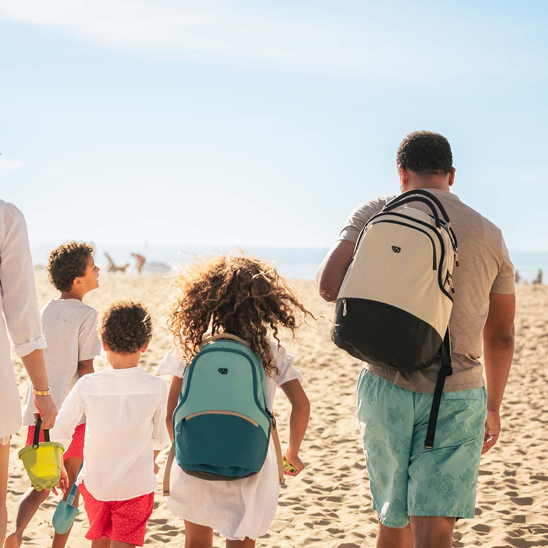 Family at the beach with a high-quality backpack for parents: The Daily Pack