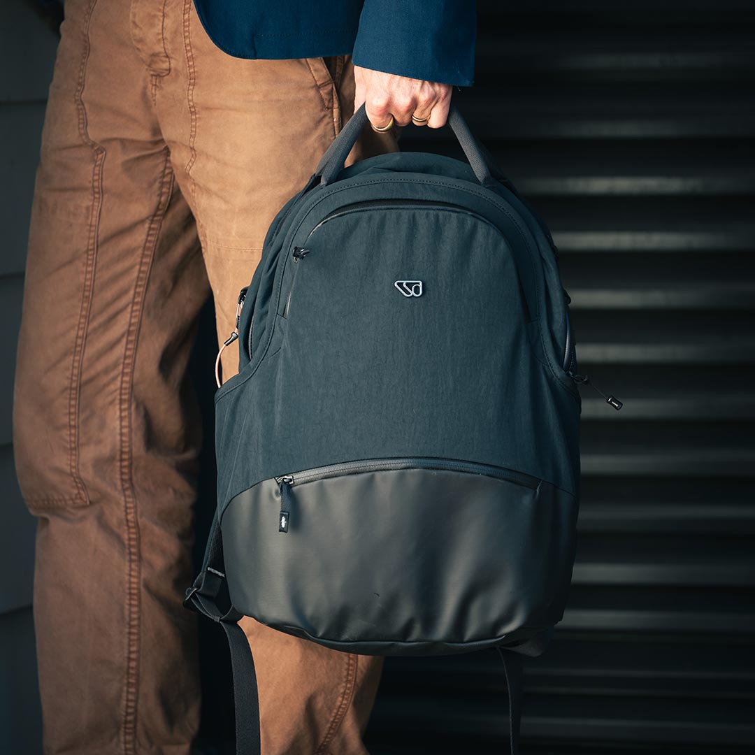 Person holding The Daily Pack high-quality backpack for parents