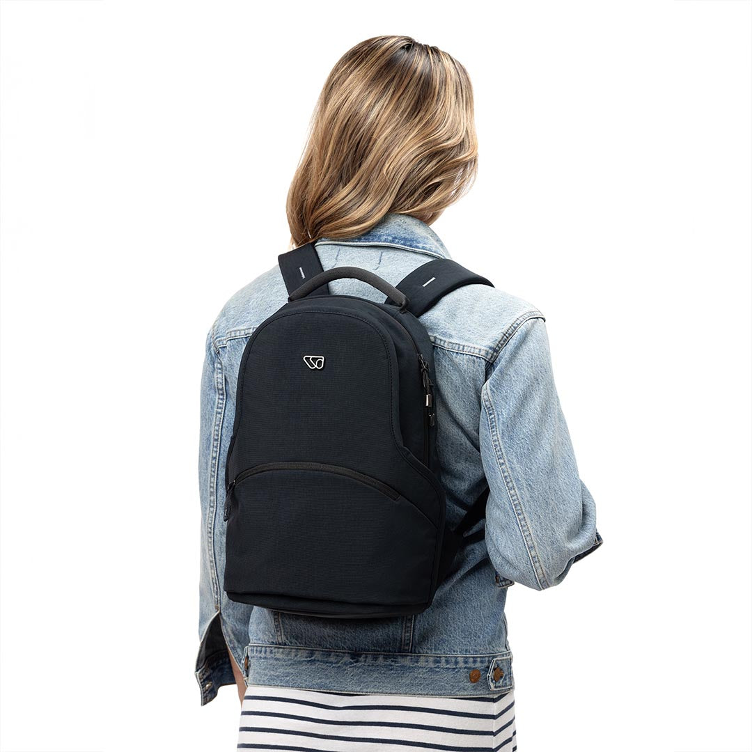 Woman carrying The Mini Pack travel backpack for parents