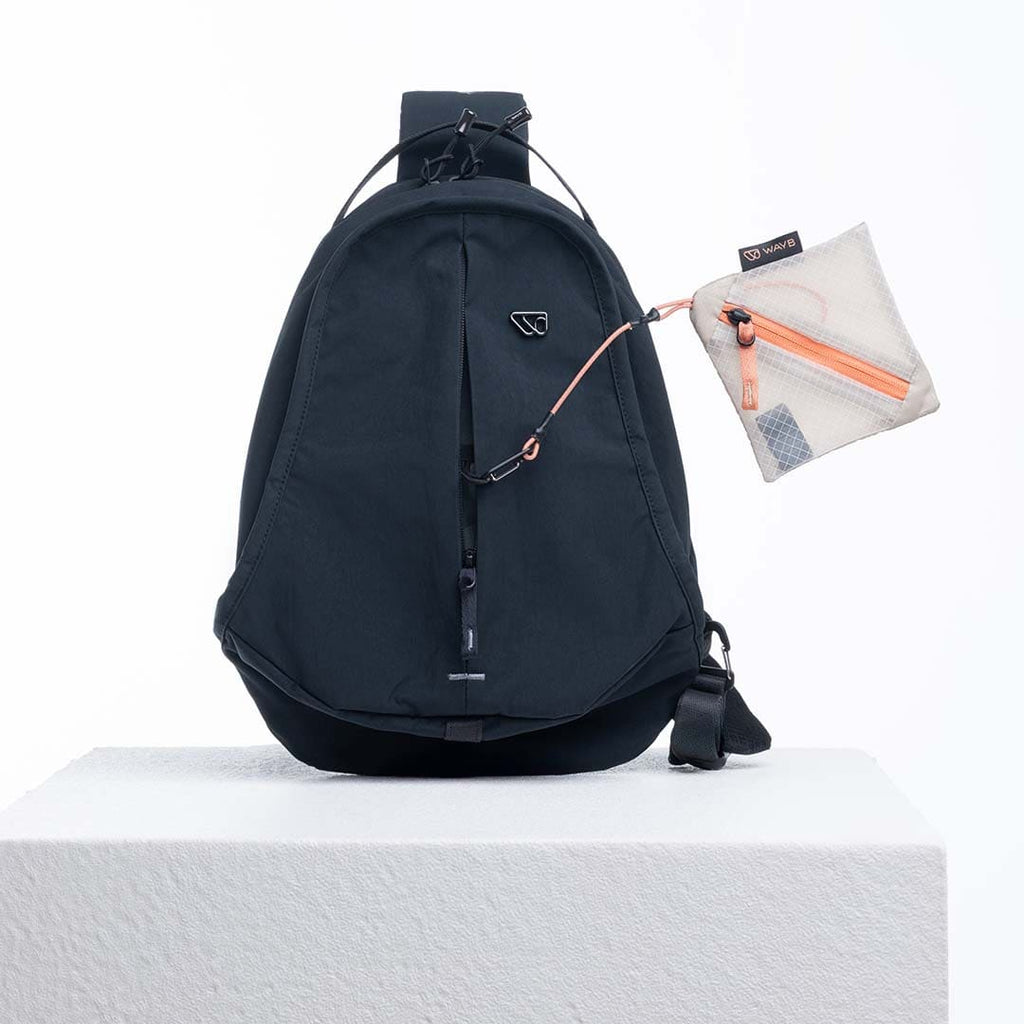 Black sling bag with a small pouch on a white background
