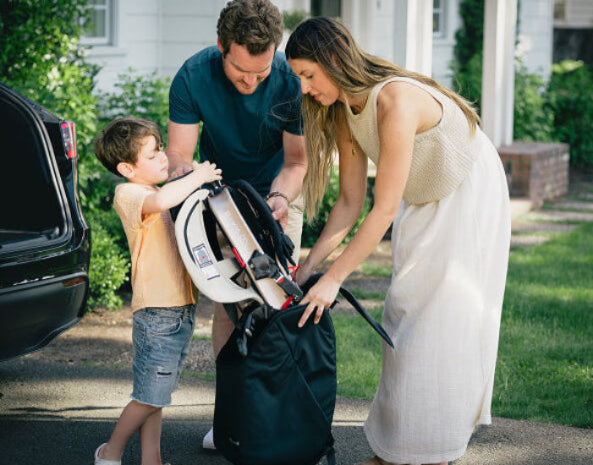 Family with young child packing WAYB Pico Car Seat into Carrying Bag