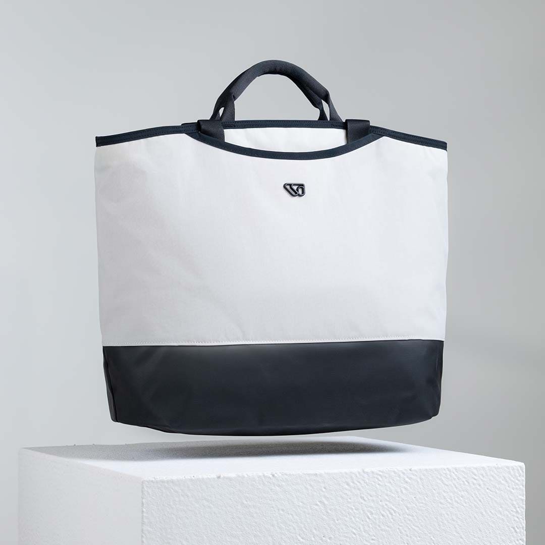 White and black tote bag on a gray background