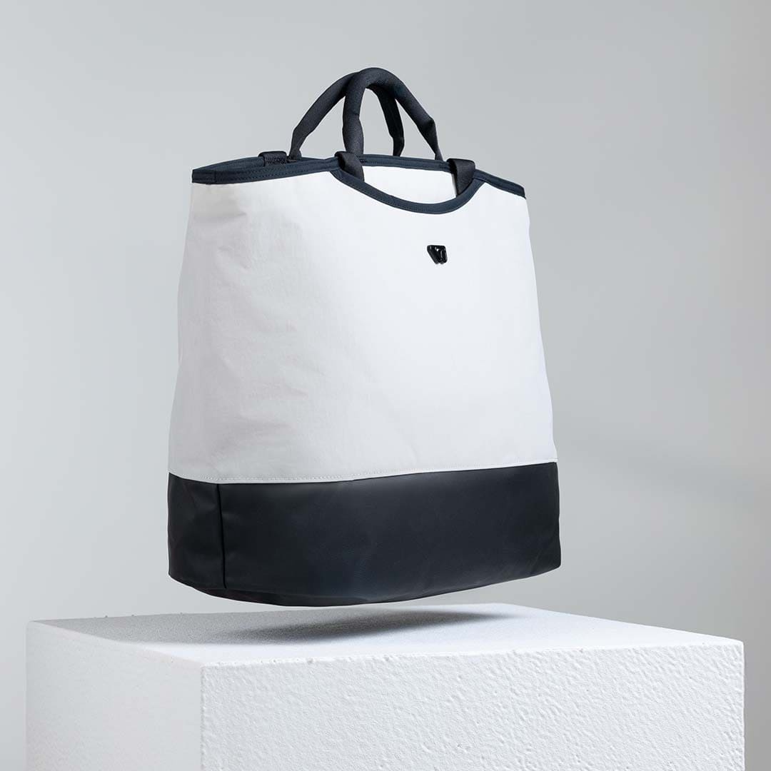 White and black tote bag on a gray background